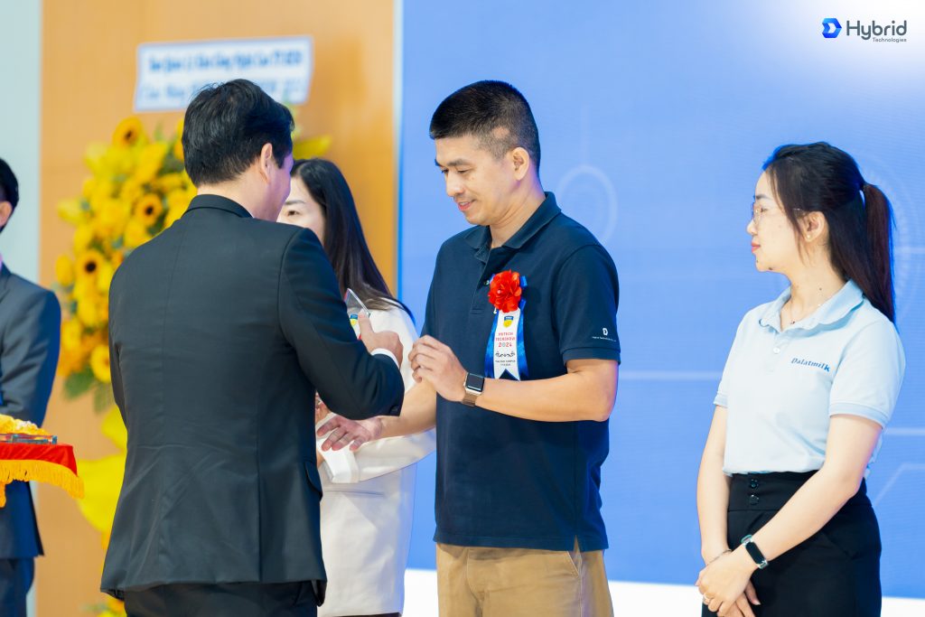 [Hình 02 - 03: Đại diện Hybrid Technologies - Anh Huỳnh Kim Long - Delivery Manager Hybrid Technologies Hồ Chí Minh nhận Thư cảm ơn và Kỉ niệm chương từ Nhà trường] 